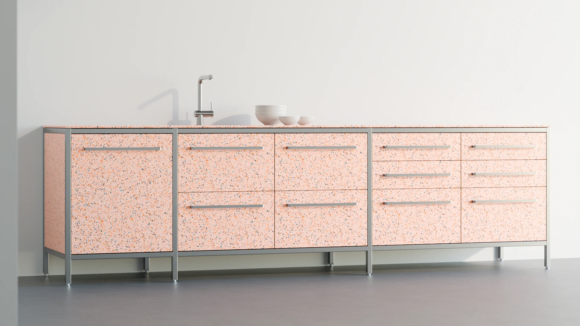 Kücheninsel mit Terrazzo-Fronten in Korallentönen, grauem Metallrahmen und integriertem Waschbecken