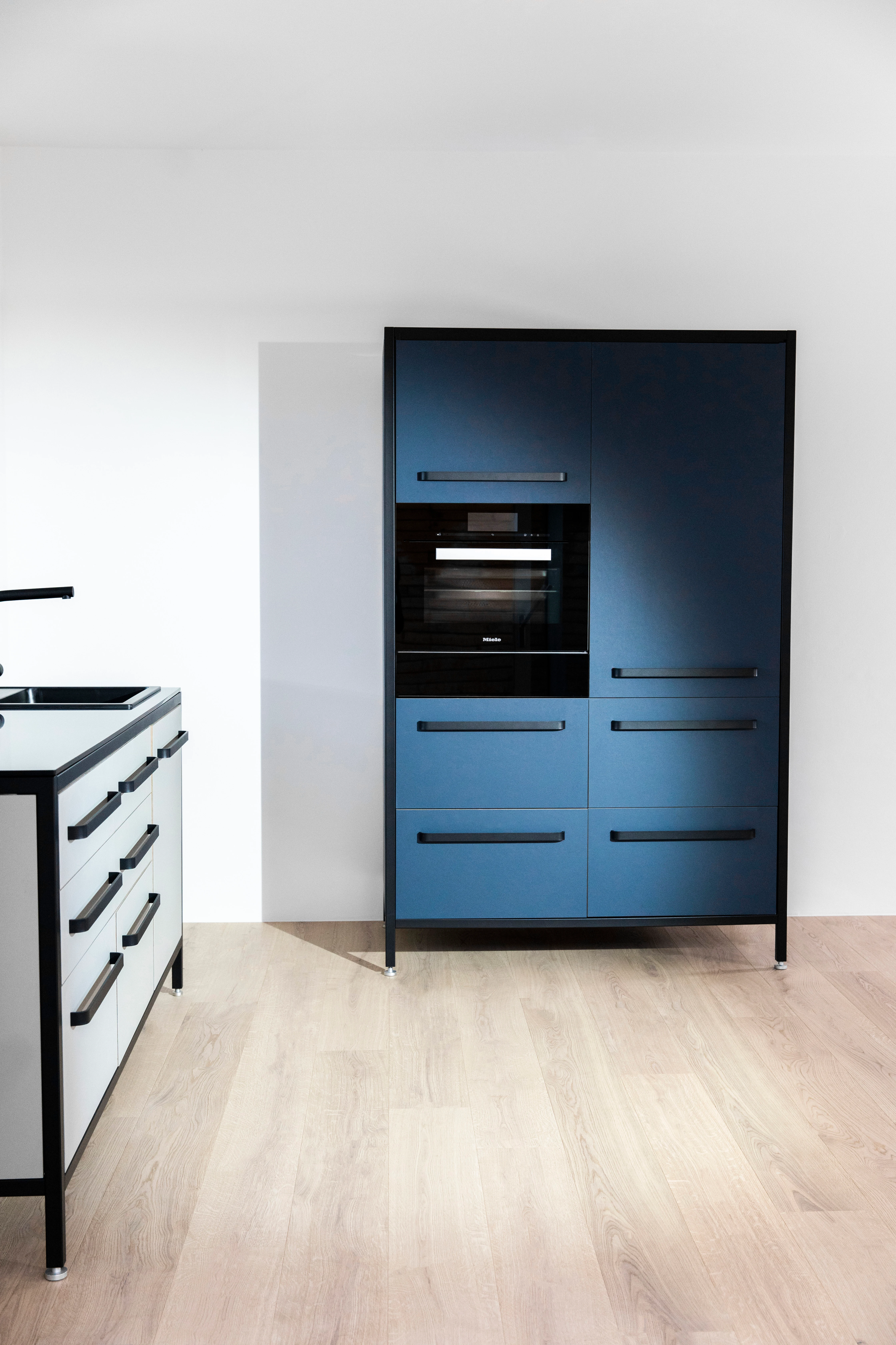 Blaue keep Modulküche mit schwarzen Rahmen im Industrial Design