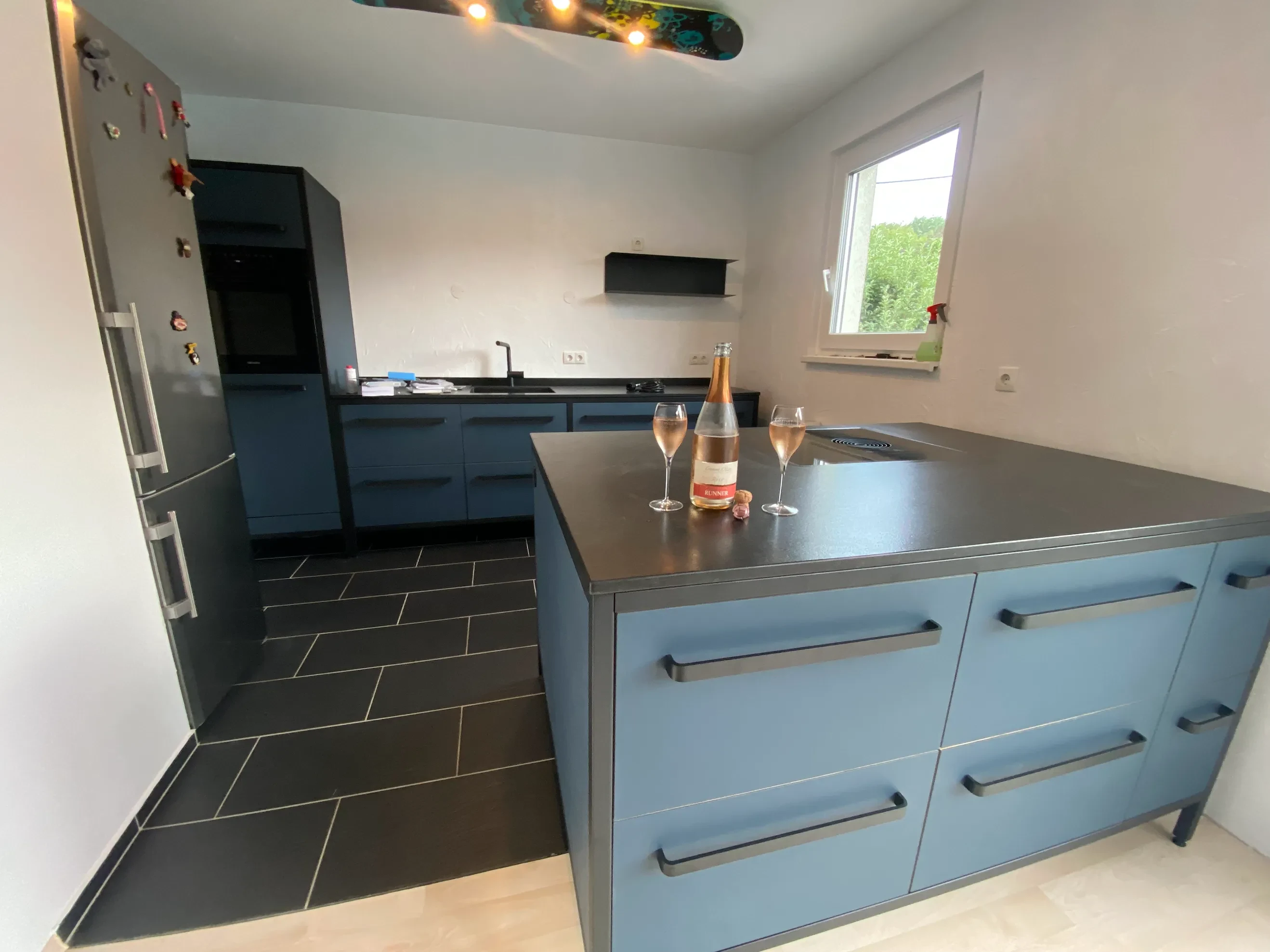 Moderne blaue kitchen to keep mit schwarzer Arbeitsplatte und Insel